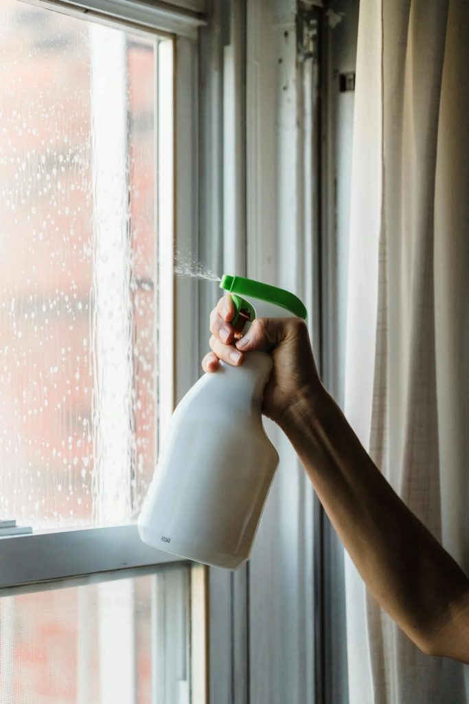 spraying-window Cleaner spraying a window with window cleaner in a home in Dallas-Fort Worth